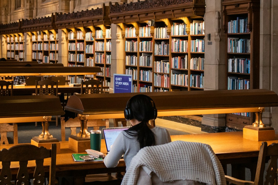 University student studying independently in a library, illustrating the relationship between AI assistance and learning without support.