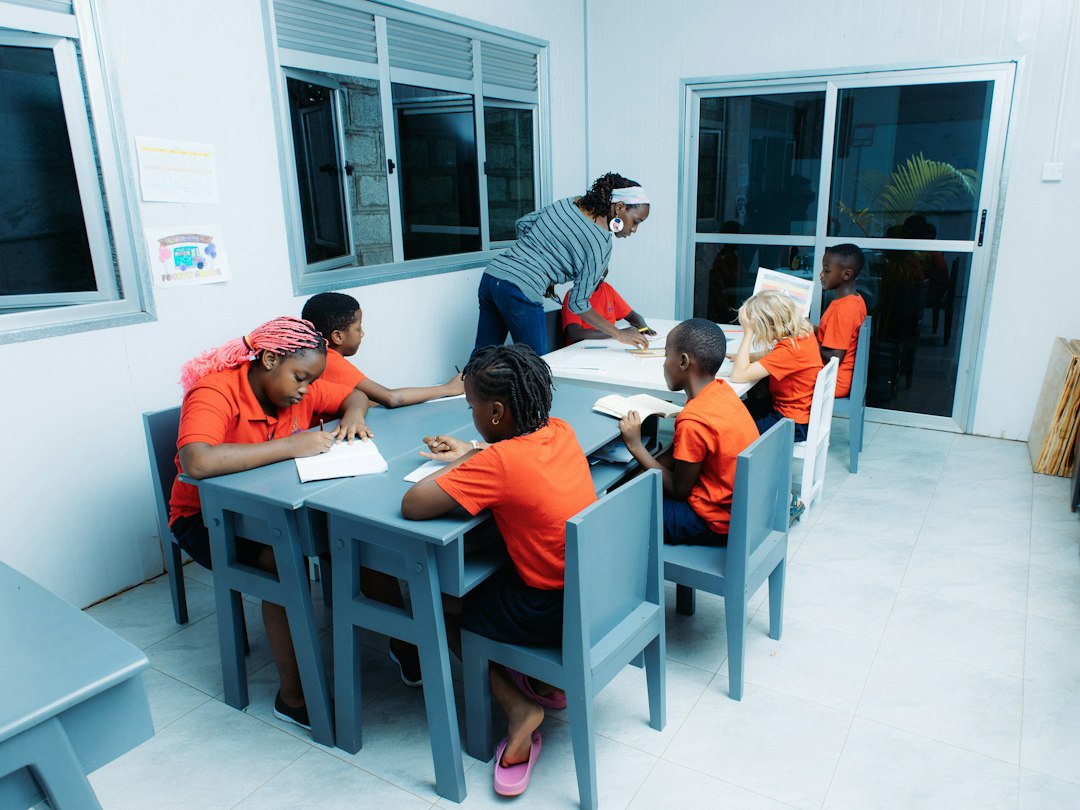 Primary-school pupils working on mathematics activities with a teacher nearby