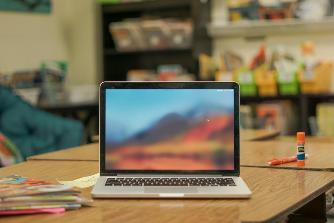 Laptop and planning materials on a classroom desk for teacher lesson design